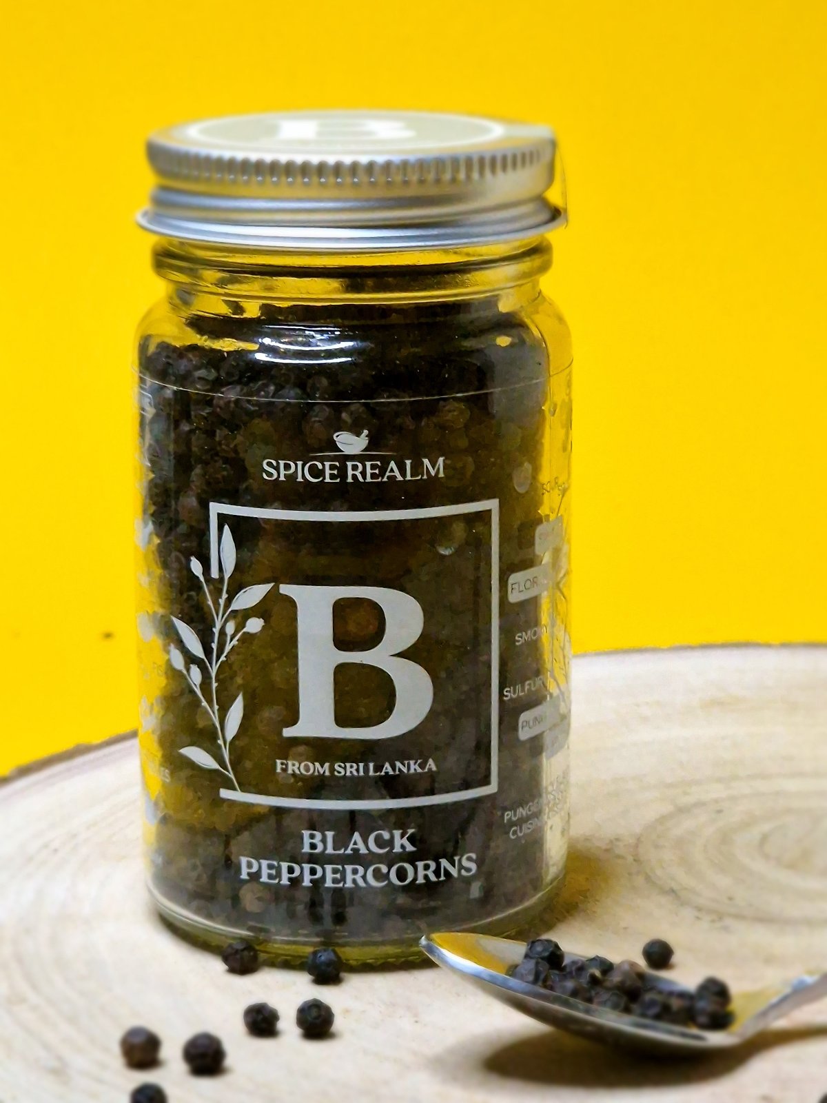 Jar of whole organic Black Peppercorns, showcasing their round shape and dark, wrinkled appearance.