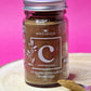 Jar of organic Ceylon Cinnamon Powder, exhibiting its light brown colour and fine, sandy texture