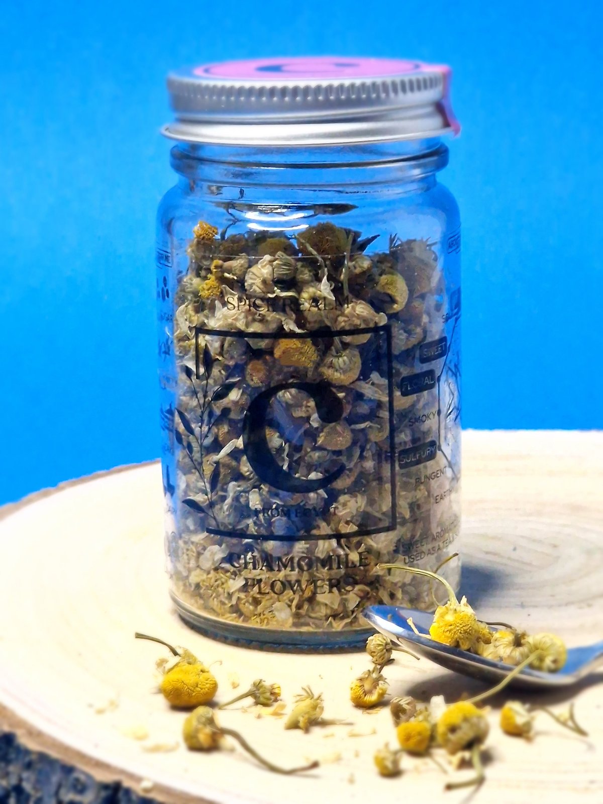 Jar of dried organic Chamomile Flowers, showcasing their small, daisy-like appearance and pale yellow colour