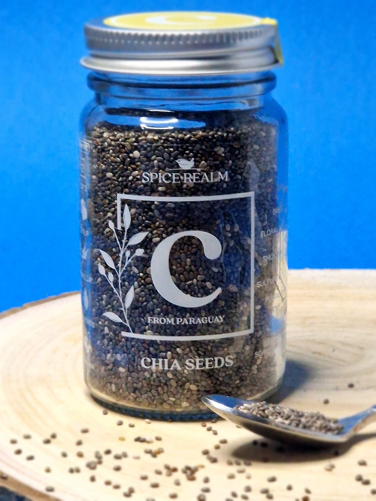 Jar of organic Chia Seeds, displaying their tiny, oval shape and speckled black and white colours