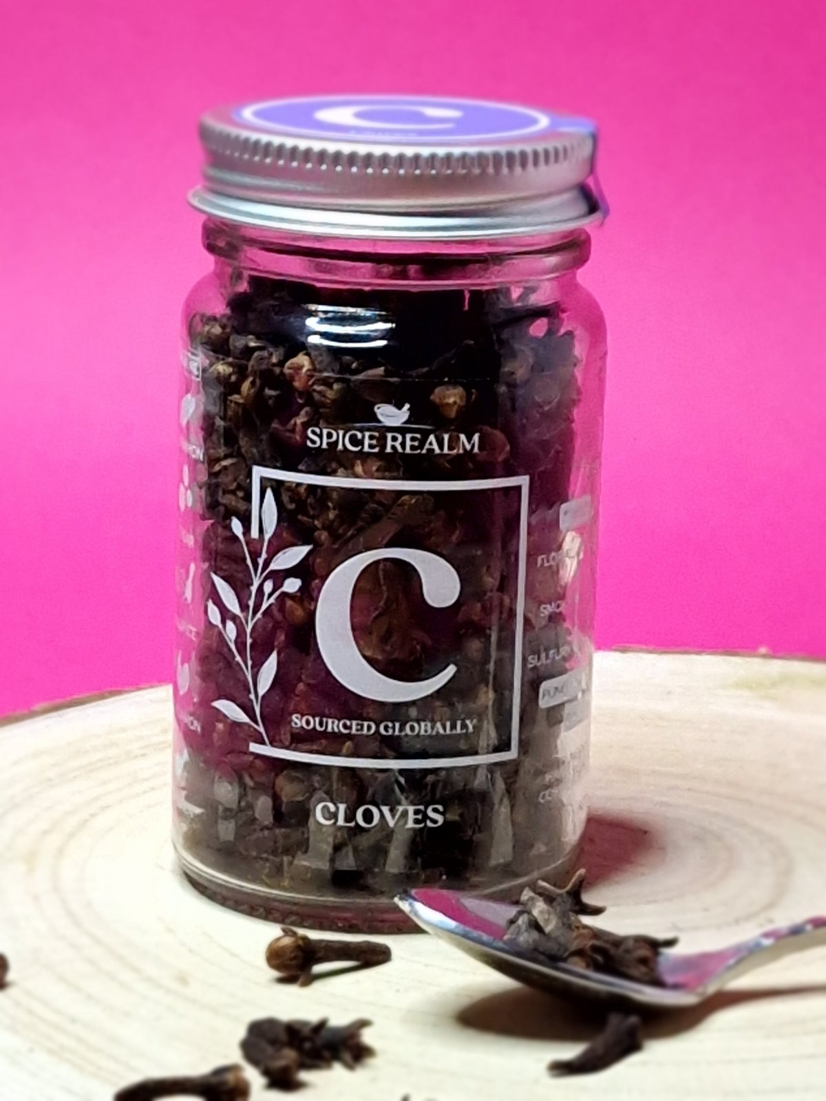 Jar of whole organic Cloves, showcasing their distinctive nail-like shape and dark brown colour