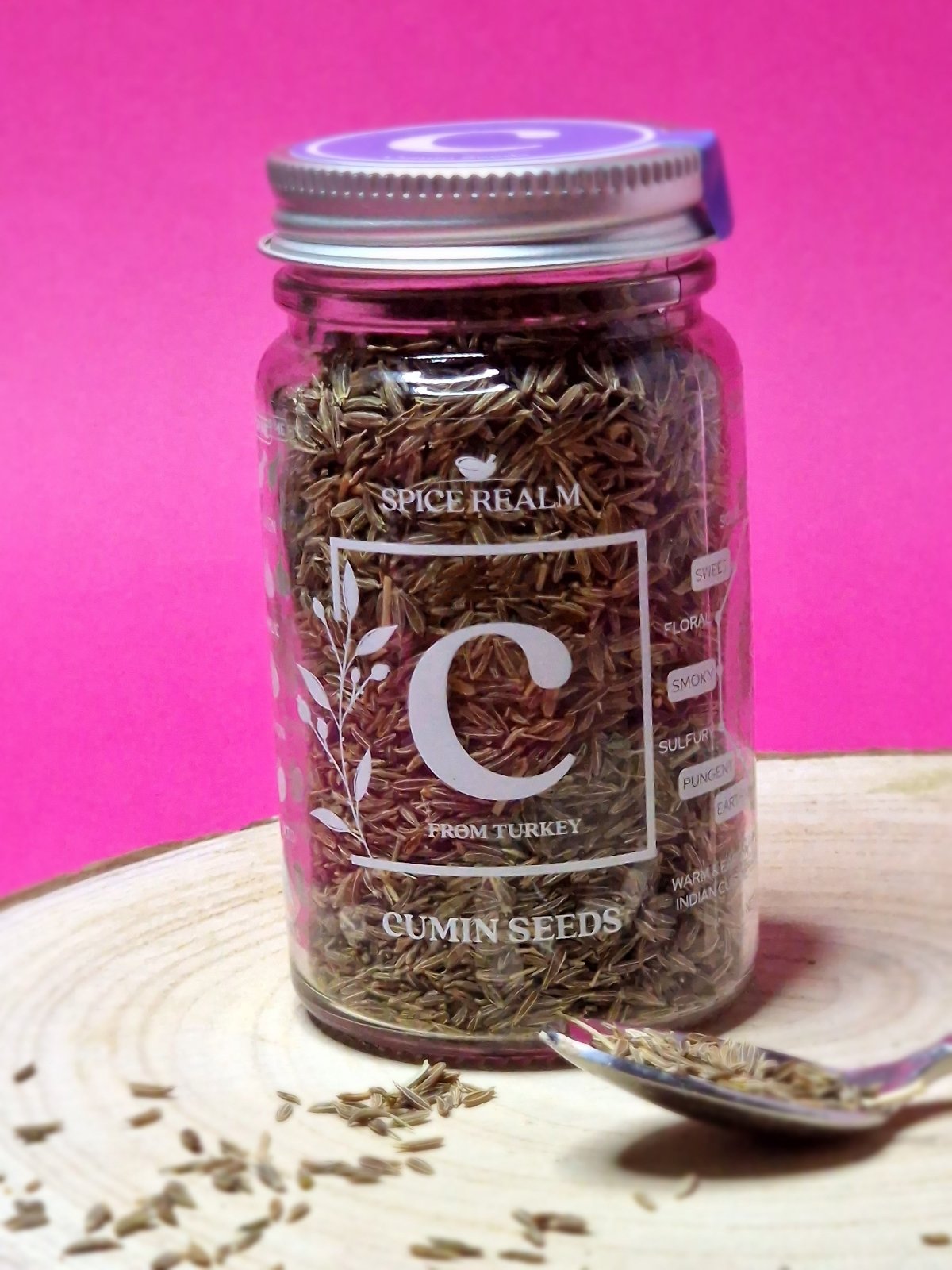 Jar of organic Cumin Seeds, displaying their oblong shape and light brown colour with ridged surfaces