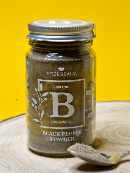 Jar of organic Black Pepper Powder, exhibiting its dark grey colour and fine, speckled texture.