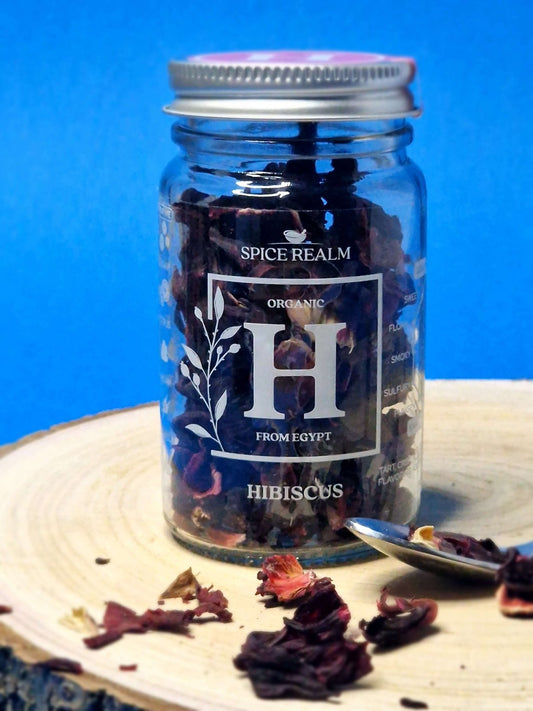 Jar of dried organic Hibiscus flowers, displaying their vibrant red colour and delicate petal structure