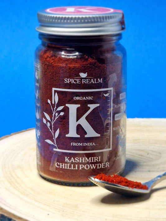 Jar of organic Kashmiri Chilli Powder, displaying its vibrant red colour and fine, powdery texture