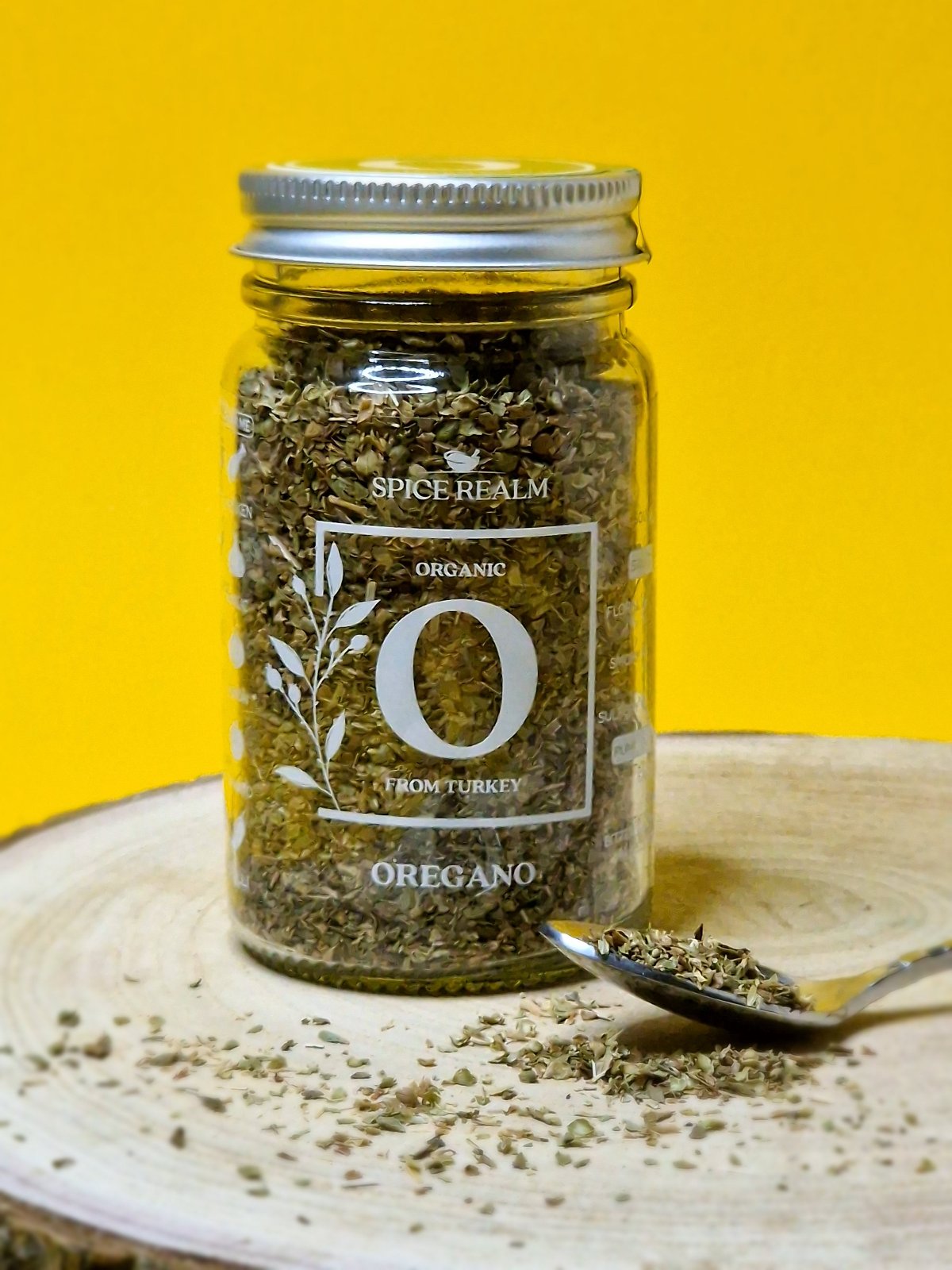 Jar of dried organic Oregano, showcasing its small, fragmented leaves and muted green colour