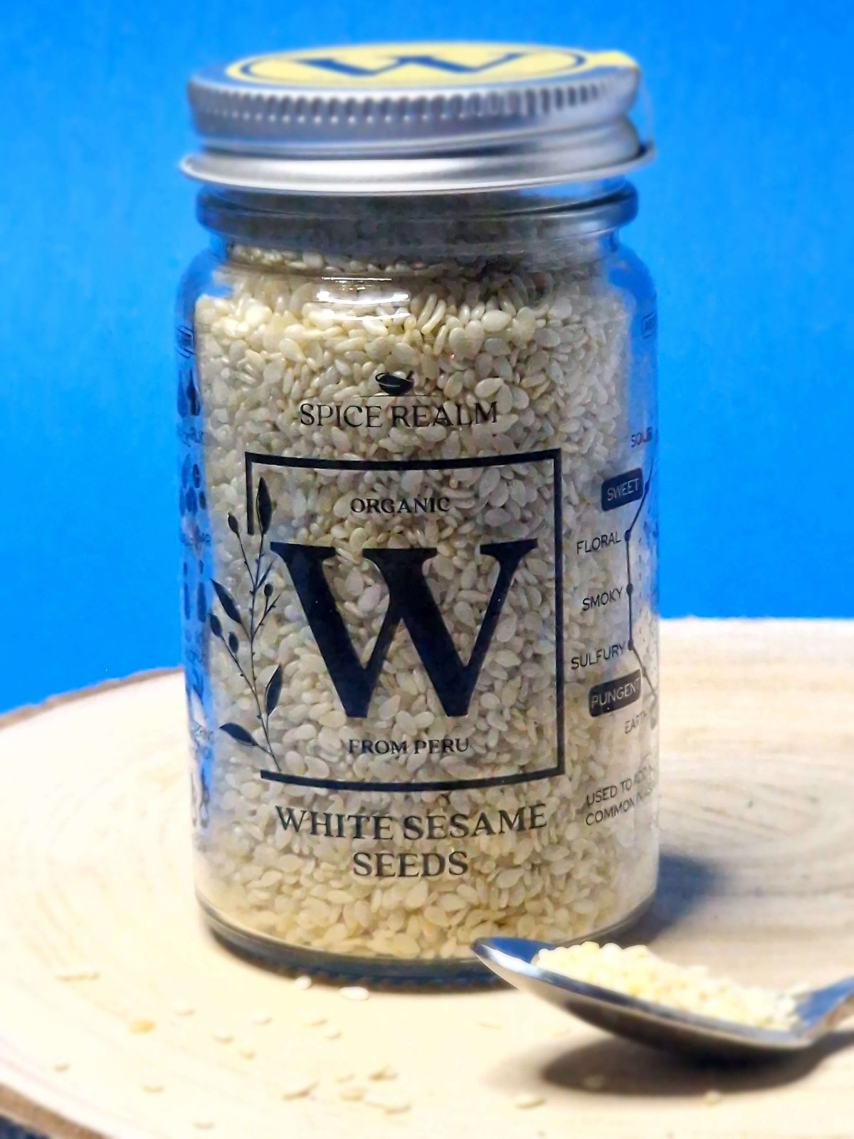 Jar of organic White Sesame Seeds, exhibiting their tiny, oval shape and creamy white colour